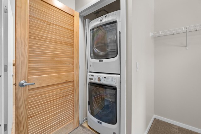 1645 W Ogden Ave Unit 304, Chicago, IL 60612 - laundry area featuring stacked washing machine and dryer, carpet, and baseboards