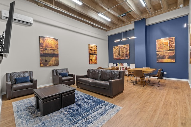 1645 W Ogden Ave Unit 304, Chicago, IL 60612 - living area with a wall mounted AC, wood finished floors, a high ceiling, and baseboards