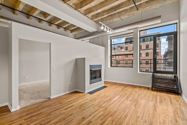 1645 W Ogden Ave Unit 304, Chicago, IL 60612 - unfurnished living room with wood finished floors, a fireplace with flush hearth, and baseboards