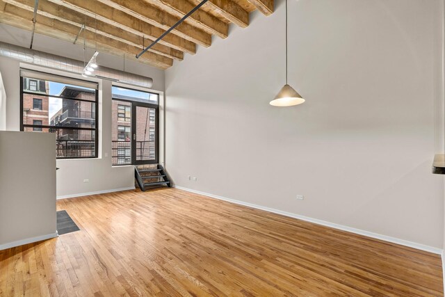 1645 W Ogden Ave Unit 304, Chicago, IL 60612 - unfurnished room featuring healthy amount of natural light, wood finished floors, baseboards, and a towering ceiling
