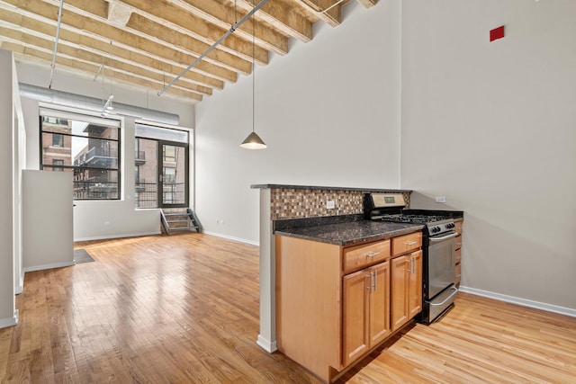 1645 W Ogden Ave Unit 304, Chicago, IL 60612 - kitchen featuring gas stove, light wood-style flooring, baseboards, a high ceiling, and brown cabinets