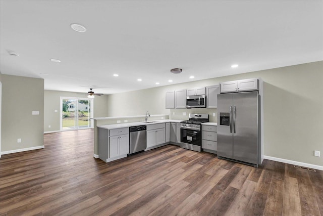 205 E Fairfield St, Fisher, IL 61843 - kitchen with appliances with stainless steel finishes, a sink, gray cabinets, a peninsula, and dark wood-style floors