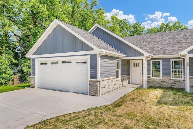 205 E Fairfield St, Fisher, IL 61843 - view of front of property featuring stone siding, concrete driveway, roof with shingles, an attached garage, and a front lawn