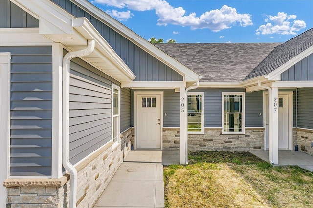 205 E Fairfield St, Fisher, IL 61843 - view of exterior entry with stone siding, a shingled roof, and board and batten siding