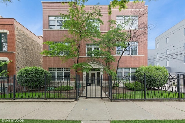 1615 N Oakley Ave Unit 2S, Chicago, IL 60647 - view of front of home with a fenced front yard, brick siding, and a gate