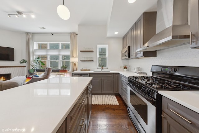 1615 N Oakley Ave Unit 2S, Chicago, IL 60647 - kitchen with gas stove, wall chimney range hood, a sink, light countertops, and recessed lighting