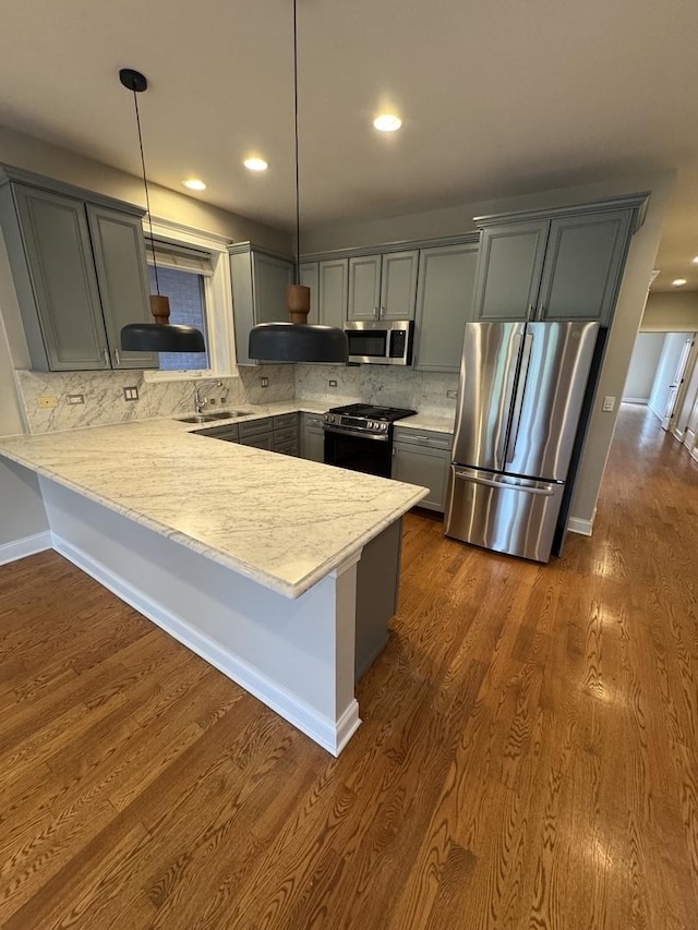 1304 N Wood St Unit 2, Chicago, IL 60622 - kitchen featuring stainless steel appliances, a sink, a peninsula, light countertops, and gray cabinets