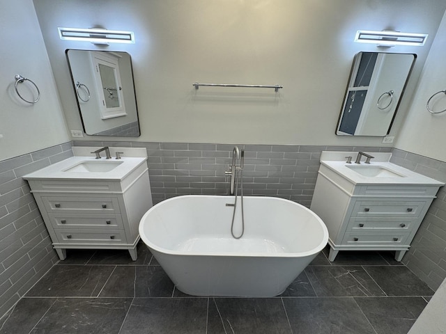 1304 N Wood St Unit 2, Chicago, IL 60622 - bathroom with tile walls, two vanities, a soaking tub, and wainscoting
