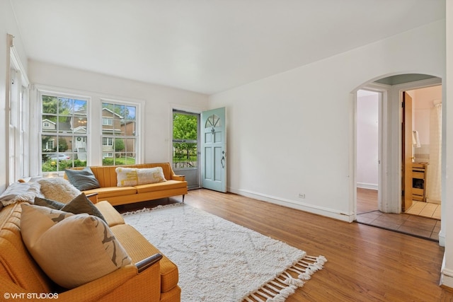 5748 N Lansing Ave, Chicago, IL 60646 - living room with arched walkways, wood finished floors, and baseboards