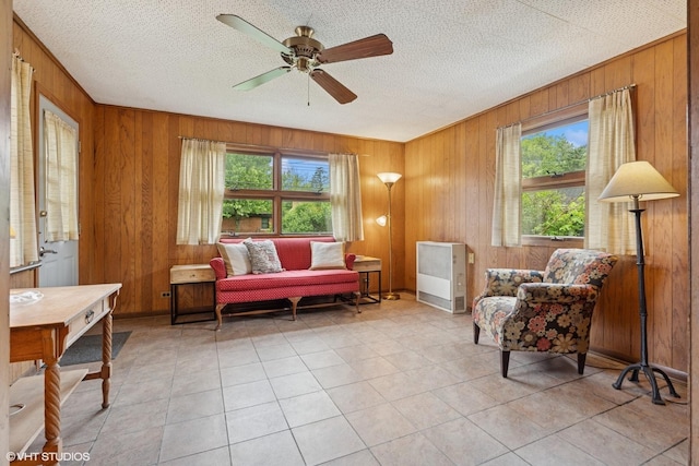 5748 N Lansing Ave, Chicago, IL 60646 - living area with wood walls, light tile patterned flooring, a ceiling fan, and a textured ceiling