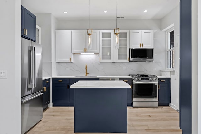 6233 S Woodlawn Ave Unit 2, Chicago, IL 60637 - kitchen with stainless steel appliances, blue cabinets, a sink, light wood-style floors, and recessed lighting