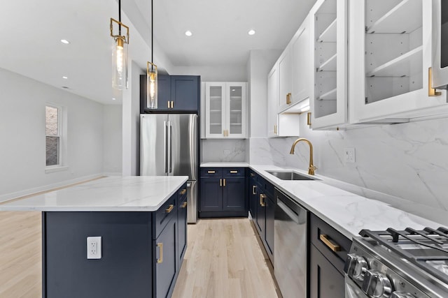 6233 S Woodlawn Ave Unit 2, Chicago, IL 60637 - kitchen with appliances with stainless steel finishes, a sink, blue cabinets, a center island, and light wood-style flooring