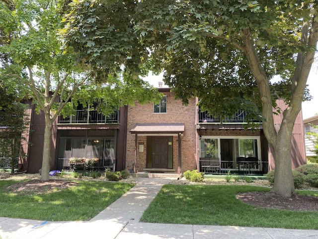 17612 71st Ct Unit 1N, Tinley Park, IL 60477 - view of front facade with a balcony, brick siding, and a front lawn