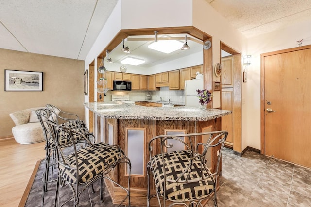 5555 N Cumberland Ave Unit 309, Chicago, IL 60656 - kitchen with white appliances, a kitchen breakfast bar, decorative backsplash, and a textured ceiling