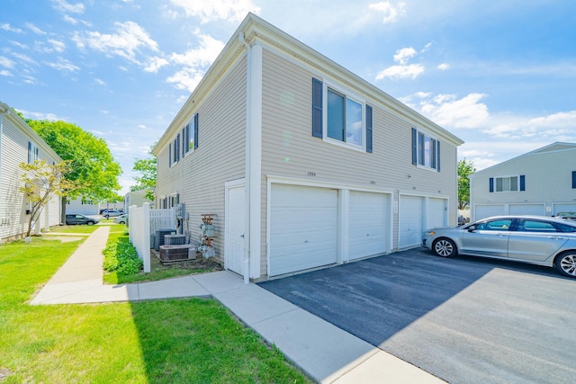 1352 Quaker Ln Unit 154C, Prospect Heights, IL 60070 - view of side of home with asphalt driveway, a garage, and a yard