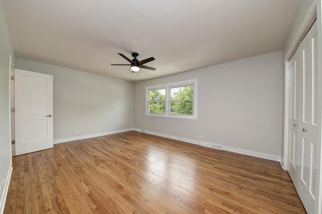 1770 Henley St Unit C, Glenview, IL 60025 - unfurnished bedroom featuring a closet, baseboards, light wood-type flooring, and ceiling fan