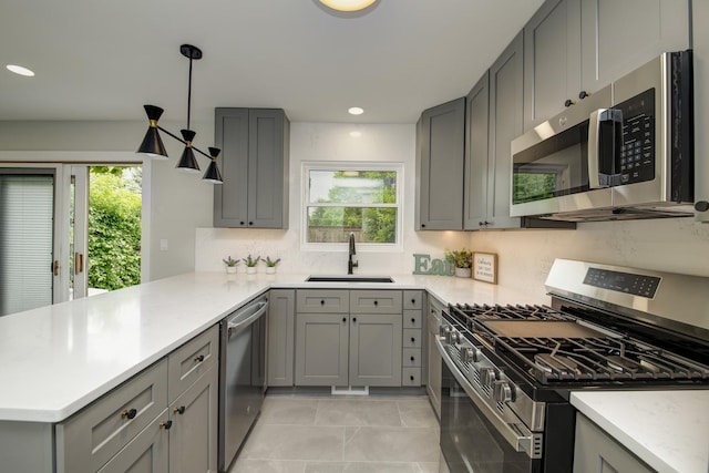 1770 Henley St Unit C, Glenview, IL 60025 - kitchen featuring stainless steel appliances, a sink, gray cabinets, a peninsula, and plenty of natural light