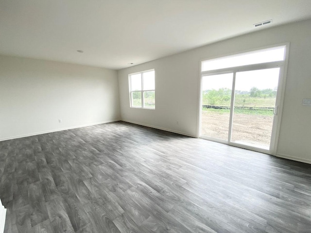 empty room featuring dark wood-type flooring and baseboards