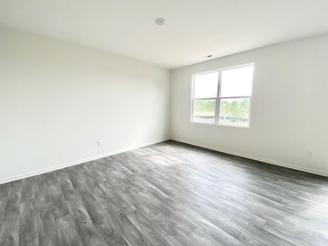 spare room with dark wood-style flooring and baseboards