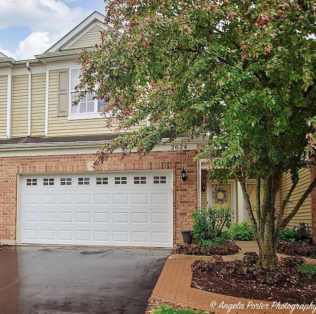 2624 Evergreen Cir, Mchenry, IL 60050 - view of front facade with driveway, brick siding, and a garage