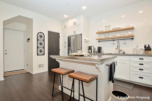 2624 Evergreen Cir, Mchenry, IL 60050 - kitchen with stainless steel fridge, a breakfast bar, a sink, white cabinetry, and a center island