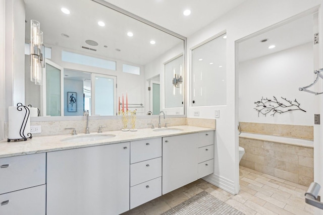 600 N Kingsbury Ave Unit 506, Chicago, IL 60610 - full bathroom with double vanity, recessed lighting, toilet, a relaxing tiled tub, and tile patterned floors