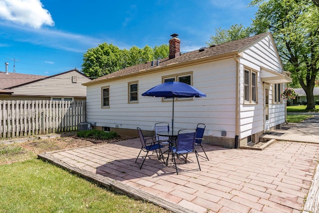 711 Parkside Dr, Rockford, IL 61108 - back of property featuring a chimney, a patio area, central AC, and a shingled roof