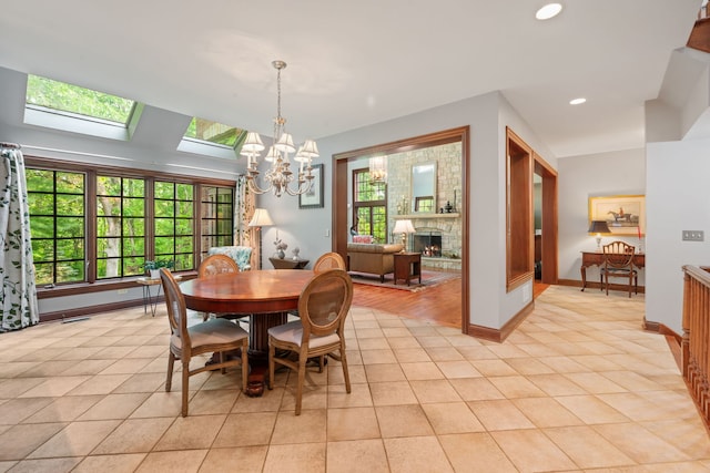 38W250 Burr Road Ln, Saint Charles, IL 60175 - dining area with a chandelier, a skylight, light tile patterned floors, a large fireplace, and recessed lighting