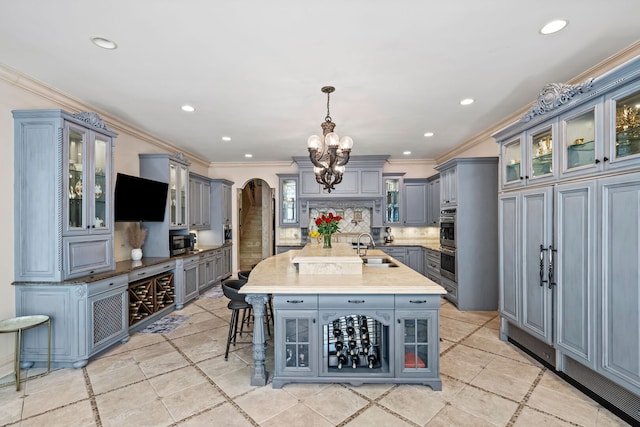 115 Carmela Ct, Bloomingdale, IL 60108 - kitchen with gray cabinets, a sink, arched walkways, a chandelier, and a kitchen bar