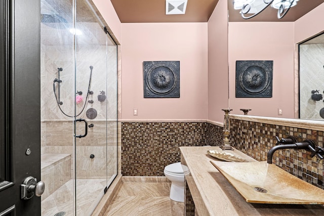 115 Carmela Ct, Bloomingdale, IL 60108 - bathroom featuring toilet, a stall shower, a wainscoted wall, vanity, and tile walls