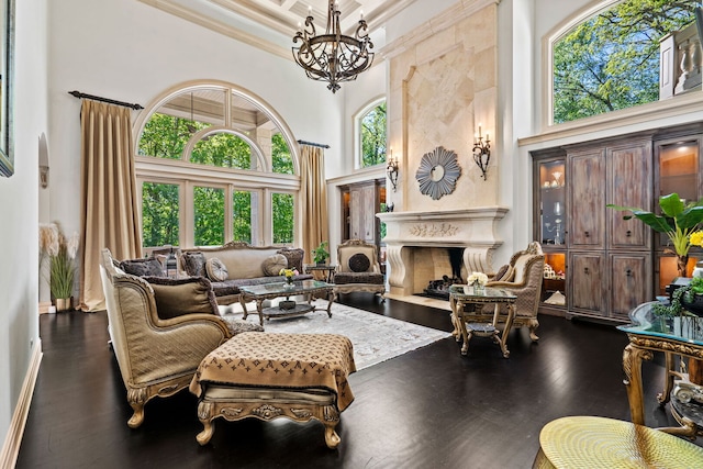 115 Carmela Ct, Bloomingdale, IL 60108 - living area featuring a towering ceiling, a chandelier, crown molding, dark wood-type flooring, and a fireplace with flush hearth