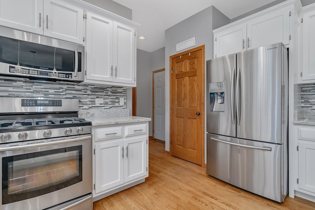 507 Cambridge Ln, Shorewood, IL 60404 - kitchen with appliances with stainless steel finishes, decorative backsplash, white cabinets, light wood finished floors, and light stone countertops