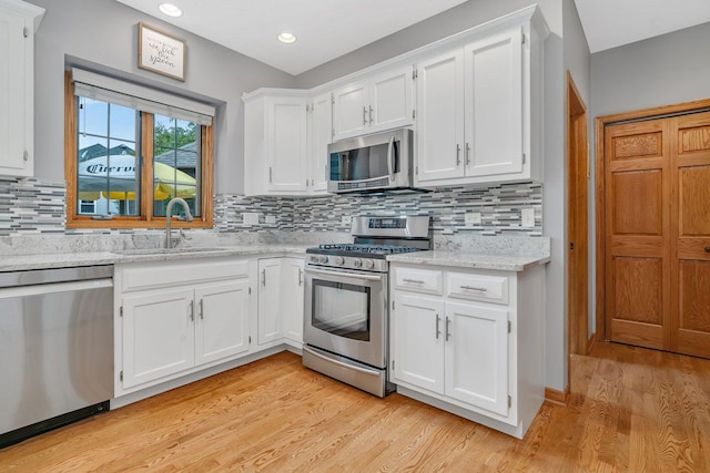 507 Cambridge Ln, Shorewood, IL 60404 - kitchen with stainless steel appliances, light wood-style floors, white cabinets, decorative backsplash, and recessed lighting