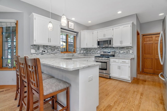 507 Cambridge Ln, Shorewood, IL 60404 - kitchen with appliances with stainless steel finishes, a peninsula, white cabinets, and recessed lighting