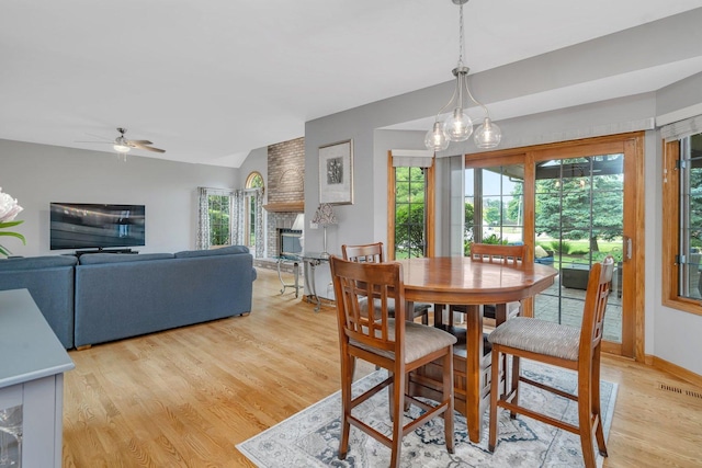 507 Cambridge Ln, Shorewood, IL 60404 - dining area with light wood-style floors, healthy amount of natural light, a fireplace, and a ceiling fan