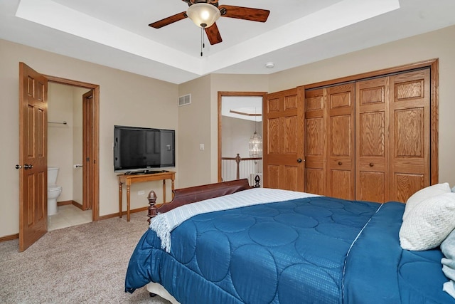 507 Cambridge Ln, Shorewood, IL 60404 - bedroom with light carpet, a tray ceiling, ensuite bath, a closet, and a ceiling fan