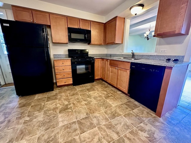 319 Triggs Ave, Elgin, IL 60123 - kitchen featuring black appliances, a chandelier, brown cabinets, light stone countertops, and light stone finish floors