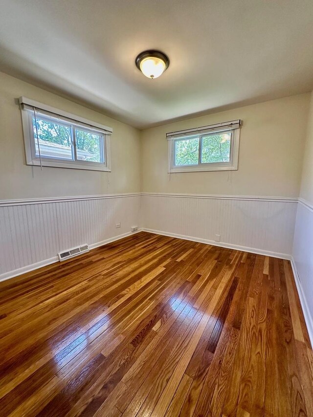 319 Triggs Ave, Elgin, IL 60123 - unfurnished room featuring wood-type flooring and a wainscoted wall