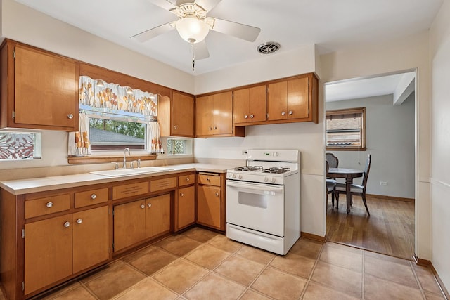 3918 213th Pl, Matteson, IL 60443 - kitchen featuring white gas stove, a sink, plenty of natural light, and brown cabinets
