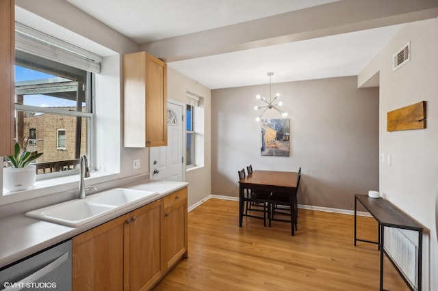 6250 N Magnolia Ave Unit 3, Chicago, IL 60660 - kitchen featuring stainless steel dishwasher, a sink, light wood finished floors, a chandelier, and baseboards