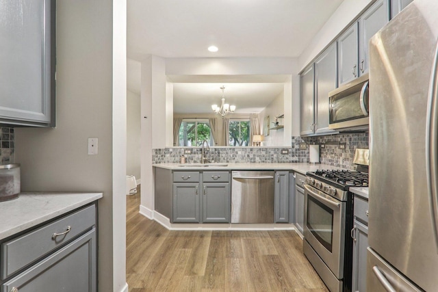 3032 Kentshire Cir, Naperville, IL 60564 - kitchen with appliances with stainless steel finishes, gray cabinets, light wood-style flooring, a chandelier, and recessed lighting