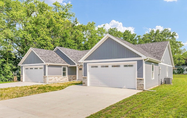 207 E Fairfield St, Fisher, IL 61843 - view of front of house featuring stone siding, roof with shingles, board and batten siding, a front lawn, and central AC unit