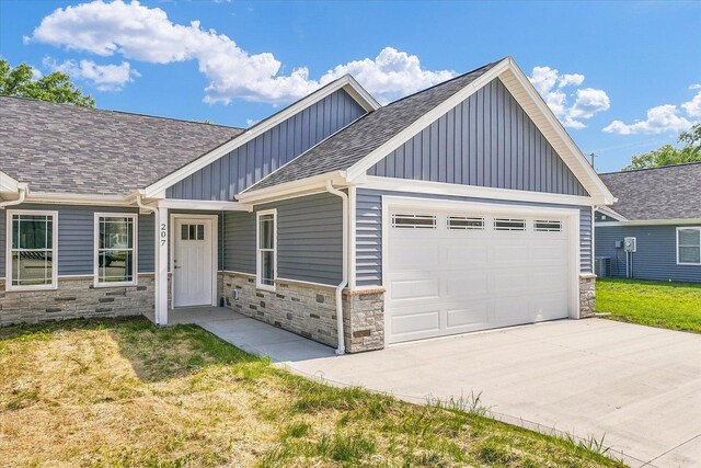 207 E Fairfield St, Fisher, IL 61843 - view of front of property with board and batten siding, stone siding, roof with shingles, and driveway