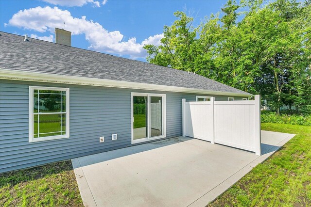 207 E Fairfield St, Fisher, IL 61843 - rear view of property featuring a patio, a shingled roof, and a chimney