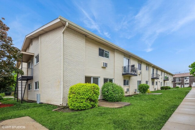 8880 Golf Rd Unit 1H, Des Plaines, IL 60016 - view of property exterior with a lawn, a balcony, and brick siding