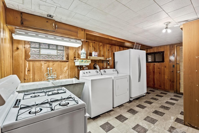 5261 N Natchez Ave, Chicago, IL 60656 - kitchen with white appliances, wood walls, light flooring, and washer and clothes dryer