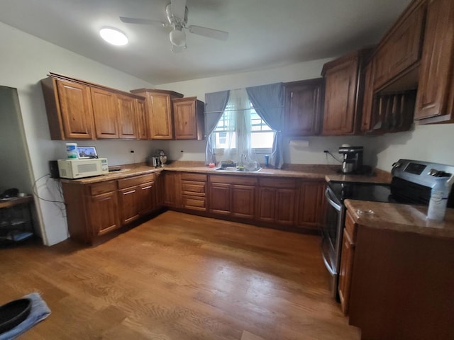 1006 N Park St, Streator, IL 61364 - kitchen with stainless steel electric stove, white microwave, light wood-style floors, and ceiling fan