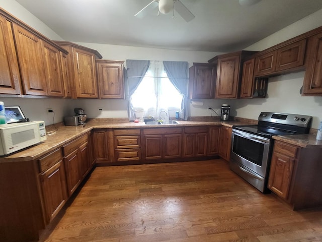 1006 N Park St, Streator, IL 61364 - kitchen featuring white microwave, stainless steel electric stove, ceiling fan, dark wood-style floors, and brown cabinets