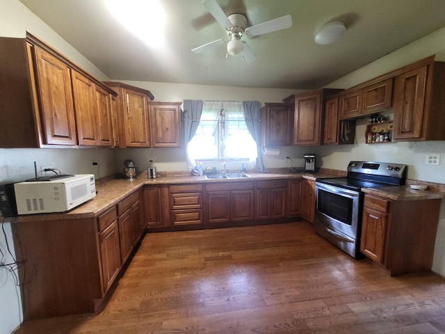 1006 N Park St, Streator, IL 61364 - kitchen with stainless steel electric stove, white microwave, a sink, a ceiling fan, and brown cabinets