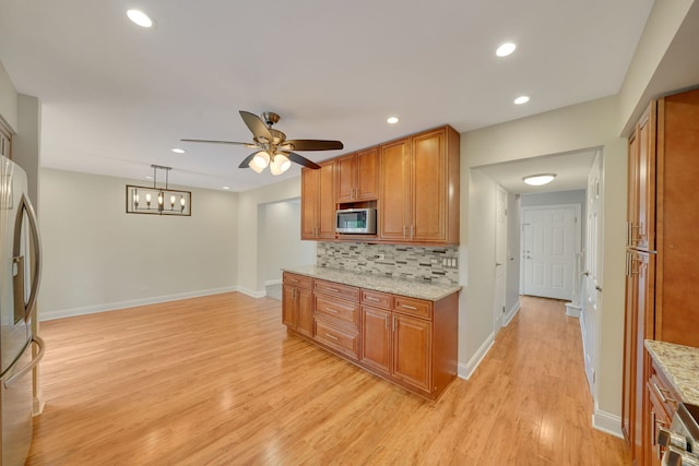 208 Spring Ct, Bloomingdale, IL 60108 - kitchen with stainless steel appliances, brown cabinetry, ceiling fan, and recessed lighting
